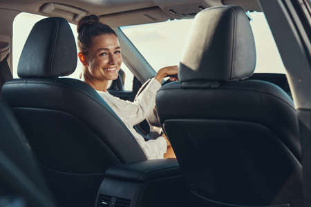 Excited female turning to rear seat while driving