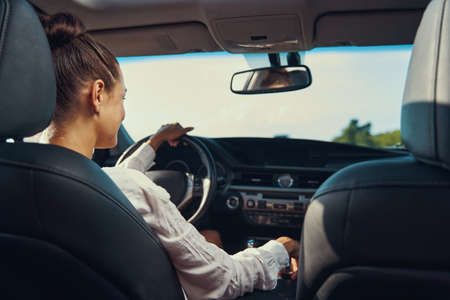 Back view of person regulating car gears while drivingの写真素材