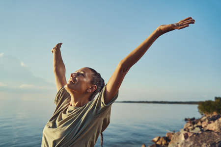 Woman raising hands up and feeling free