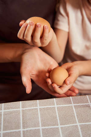 Child holding two brown eggs over open palm