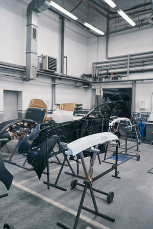 Car parts lying on supports in automobile repair shopの写真素材