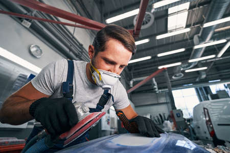 Professional car mechanic looking at grinded surfaceの写真素材