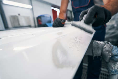 Hand sander removing white paint from metalの写真素材