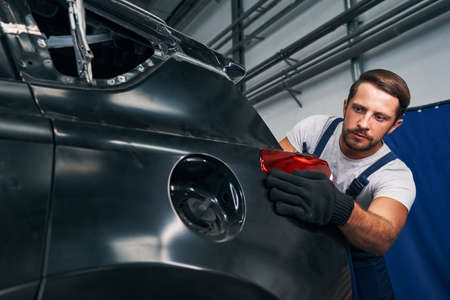 Repairman straightening rear light in its placeの写真素材