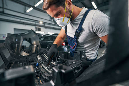 Repairman checking spare part condition with wrenchの写真素材