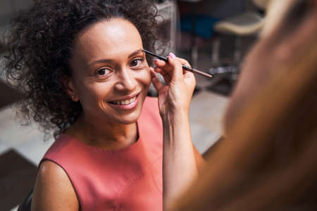 Positive delighted female looking straight at cameraの写真素材