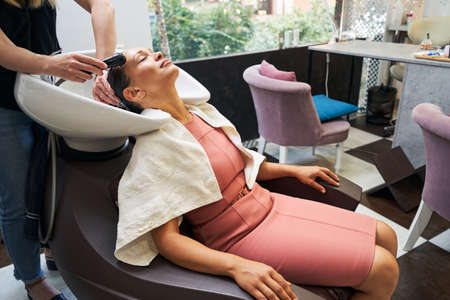 Young client enjoying beauty procedure in salonの写真素材