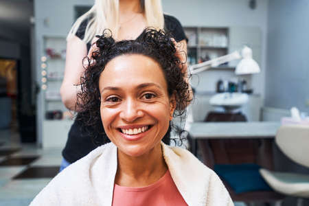 Delighted client enjoying procedure for curly hairの写真素材