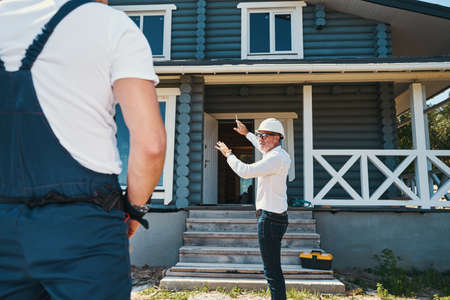 Mature construction worker explaining his plan to colleagueの写真素材