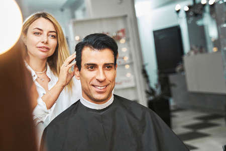 Professional hairdresser examining customer hair in salonの写真素材