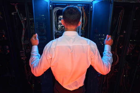 Technician standing before open door of server cabinetの写真素材