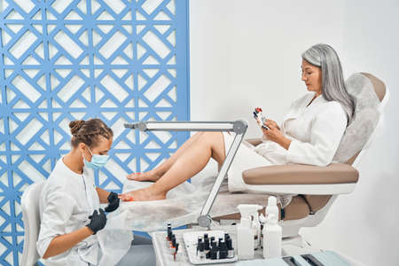 Concentrated female person choosing bright nail polishの写真素材