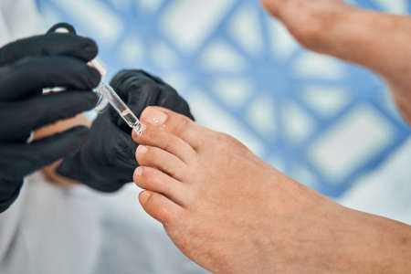Close up of specialist putting oil on nails