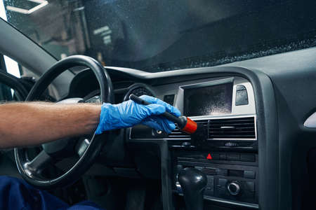 Hand of worker cleaning ventilation grills in car salonの写真素材