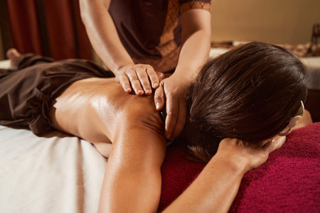 Spa customer being treated for upper back painの写真素材