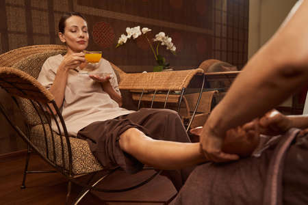 Client receiving relaxing Thai foot massage in wellness centerの写真素材