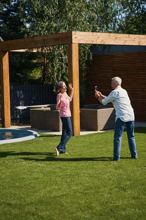 Elderly man taking photo of his senior wife