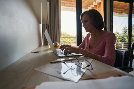 Woman who uses wheelchair working on computer