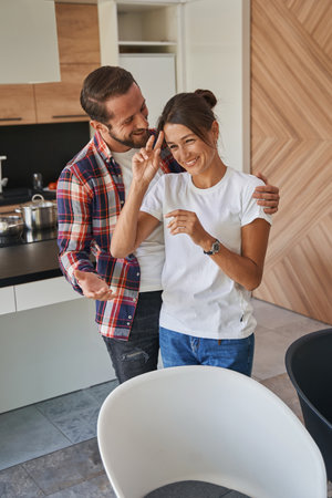 Beautiful lady and handsome male spending time together in the home apartmentsの写真素材
