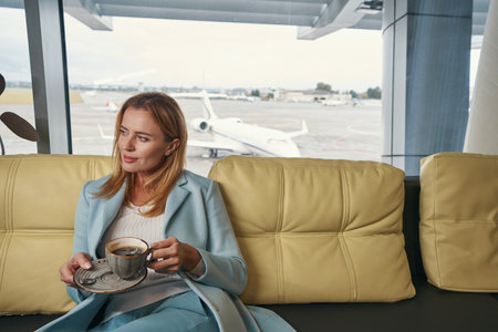 Pensive passenger having coffee in airport lounge