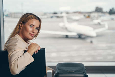 Tranquil airline passenger seated in waiting areaの写真素材