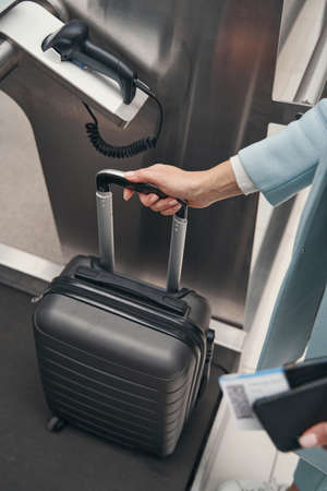 Caucasian woman using self-service baggage drop-off unit
