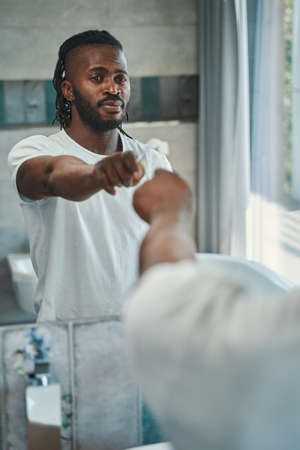 Tranquil man with toothbrush in hand standing in bathroomの写真素材