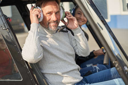 Cheerful helicopter pilot taking lady for a flightの写真素材