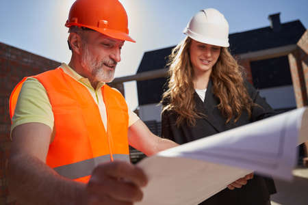 Ambitious builders studying the paper plans of the constructionの写真素材