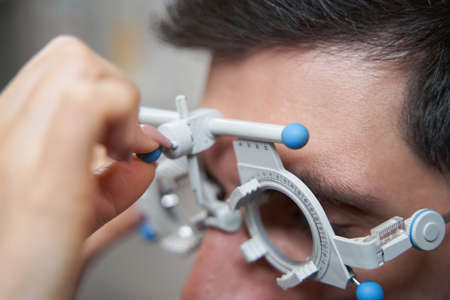 Doctor doing trial frame height adjustment for patient