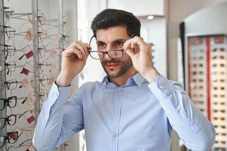 Male fitting glasses on his eye in optics storeの写真素材