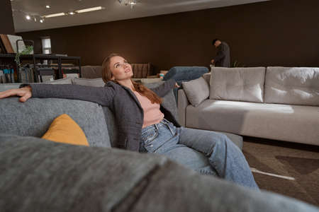 Joyful woman selecting upholstered piece of furnitureの写真素材