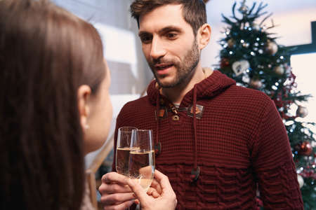 Smiling couple with glasses of champagne on Christmas eveの写真素材