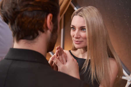 Woman looking at romantic partner while he holding her handsの写真素材
