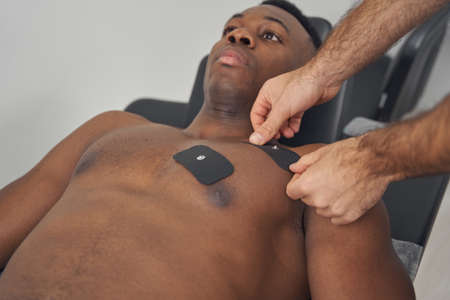 Young man being prepared for EMS sessionの写真素材