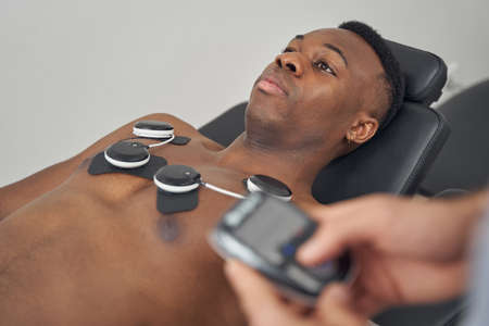 Calm young male patient receiving EMS treatmentの写真素材