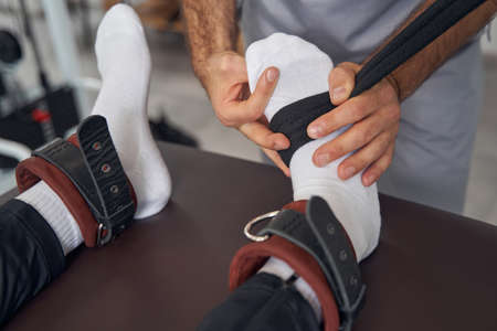 Qualified physical therapist preparing his patient for strength workoutの写真素材