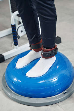 Male feet put on fitness training device at gym