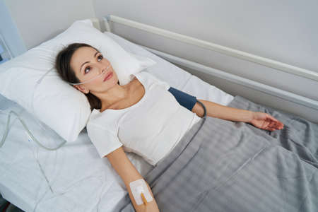 Female patient receiving supplemental oxygen through nose tubesの写真素材