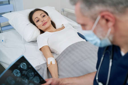 Focused neurologist examining MRI scans of young woman
