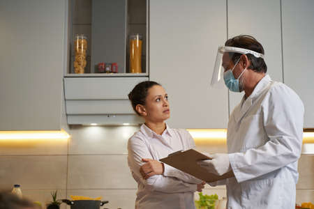 Troubled female speaking to a doctor at homeの写真素材