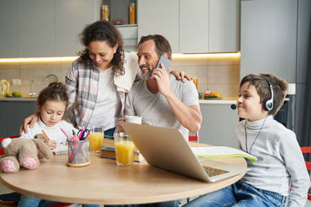 Joyful parents proud of their daughter, painting in notepad
