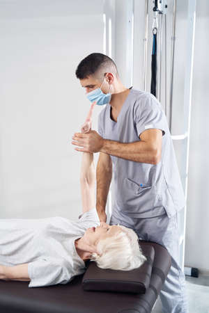 Manual therapist massaging old lady arm during rehabilitationの写真素材