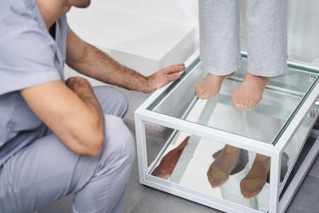 Reflection of pensioner feet in mirror for health checkの写真素材