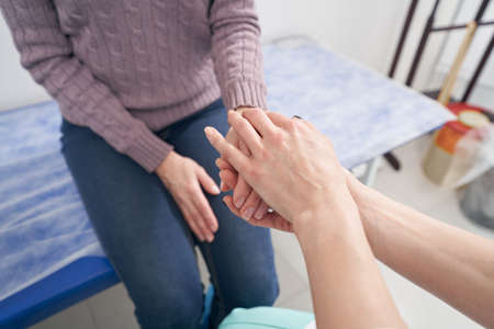 Experienced doctor comforting woman before medical exam