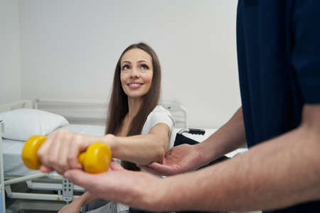 Disabled woman performing strength training exercise with physiotherapist