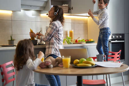 Housewife suffering from multiple home duties and naughty childrenの写真素材