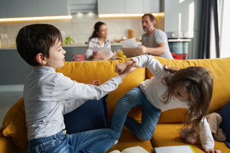 Children playing on sofa with parents in background