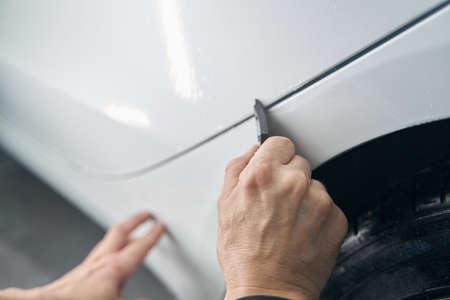Experienced detailer buffing automotive surface using toolの写真素材