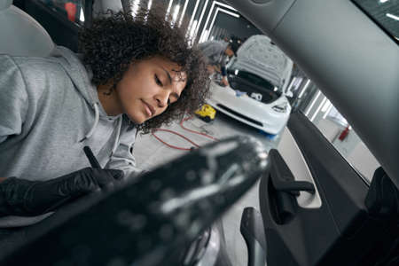 Concentrated detailer brushing dirt off vehicle interior surfacesの写真素材